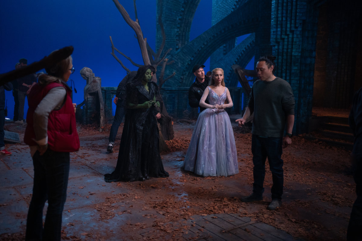 Cynthia Erivo (as Elphaba) and Ariana Grande (as Glinda) with Director Jon M. Chu