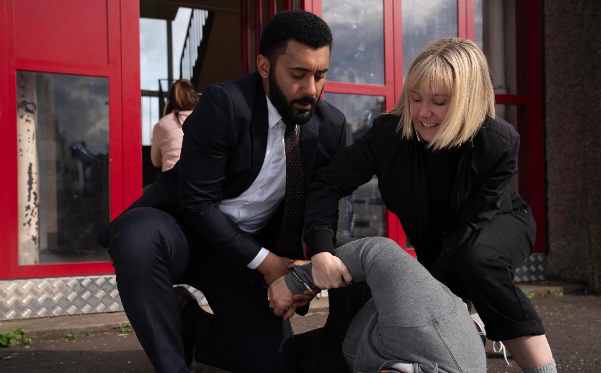 ZACH WYATT as Phil Parhatka and LAUREN LYLE as Karen Pirie