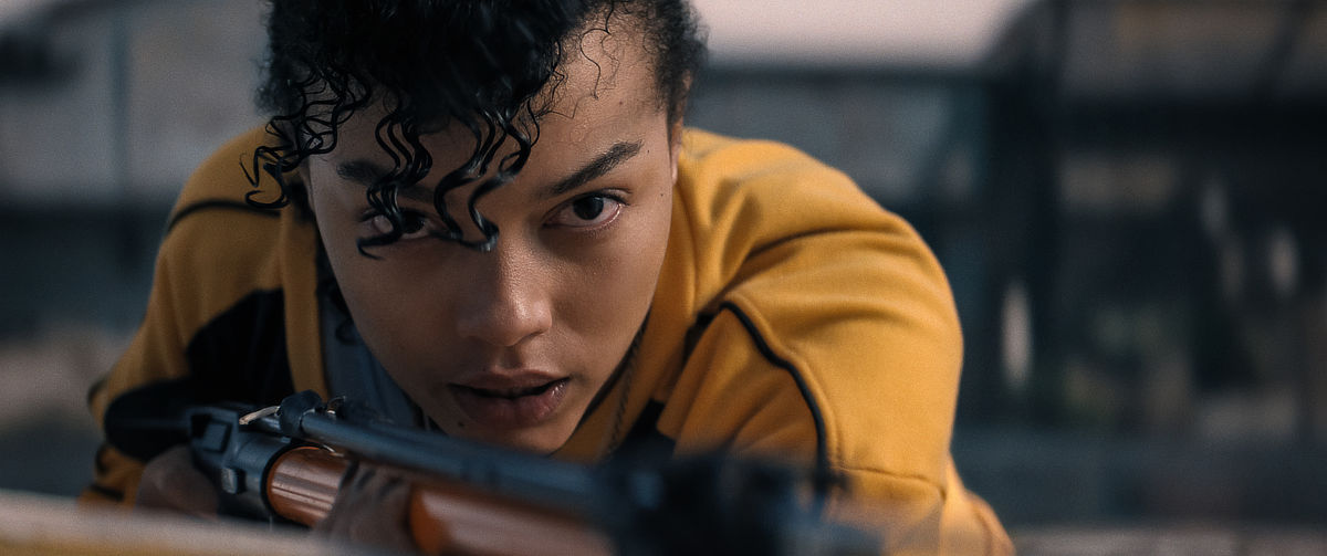 Whitney Peak in a yellow jacked with a gun