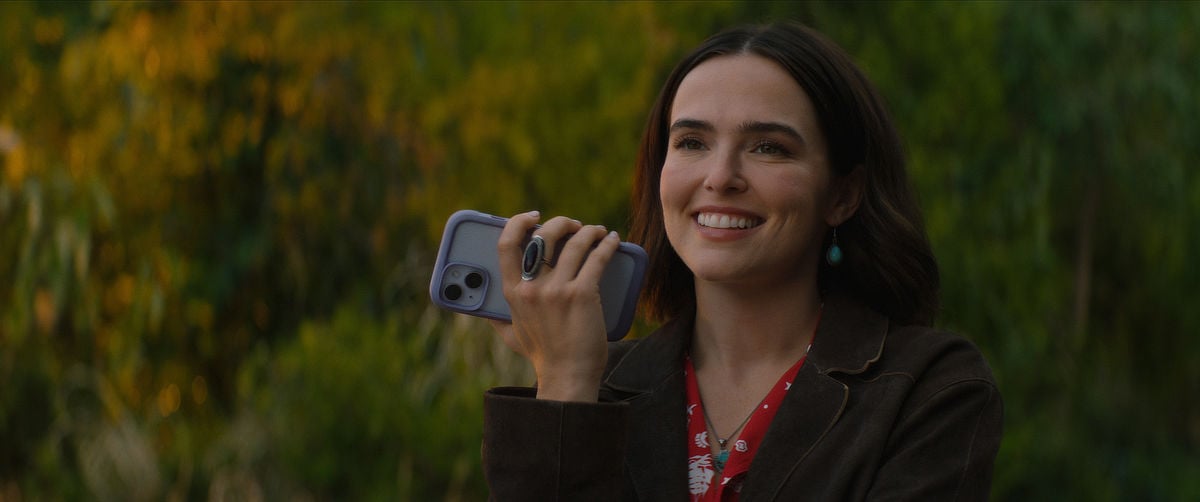 Zoey Deutch as Jill holding a phone