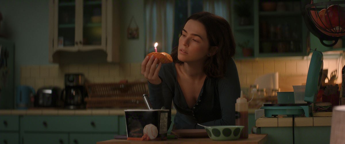 Zoey Deutch as Jill holding a lit candle
